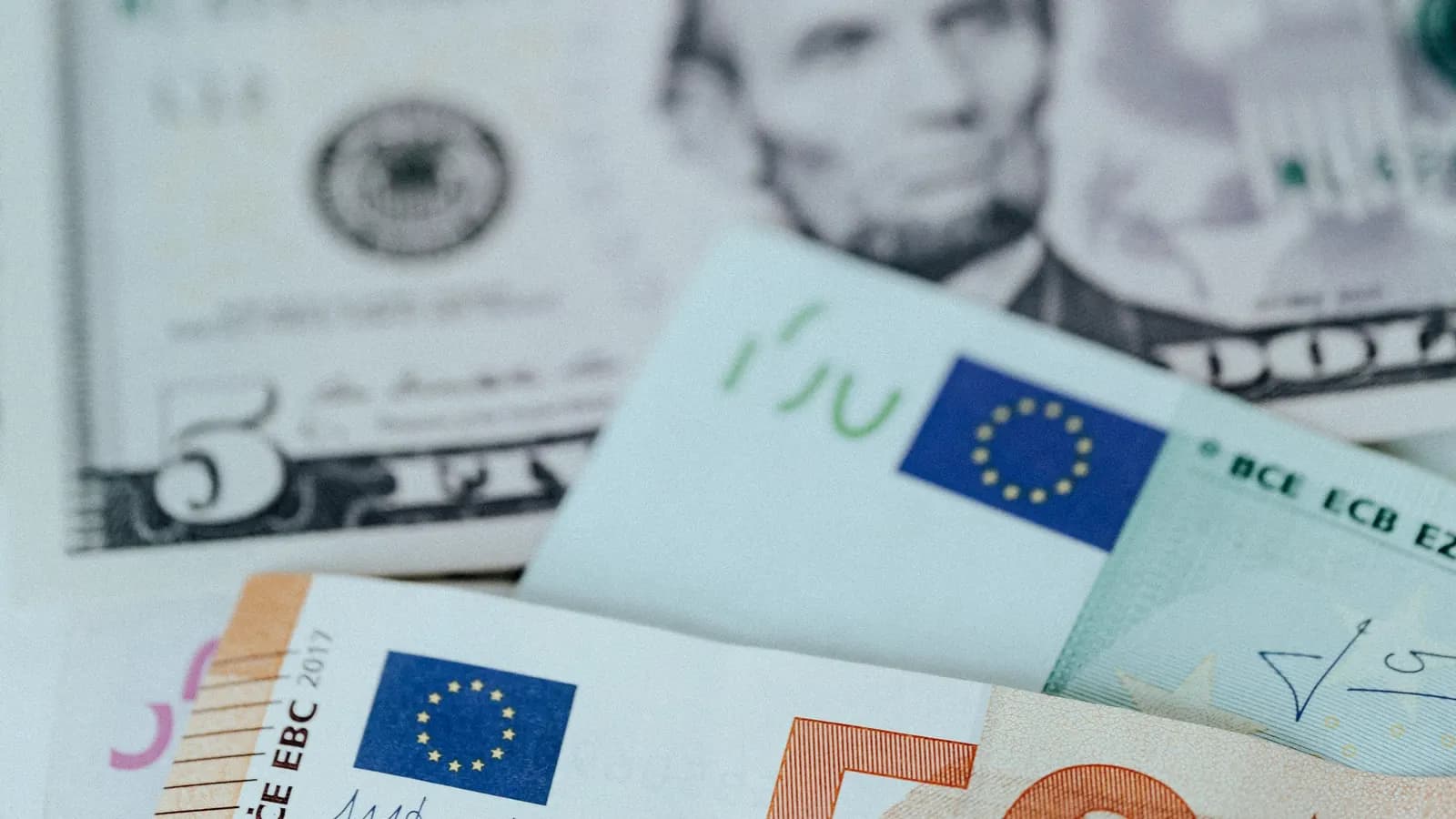 US dollar and euro banknotes spread out together.