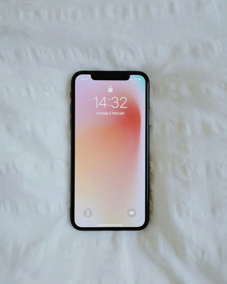 Hand holding a smartphone camera above paper documents.