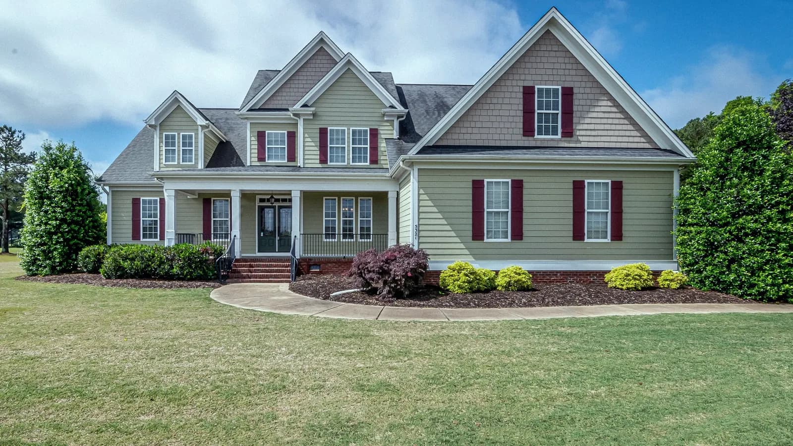 A two-storey suburban house with a front porch and lawn.